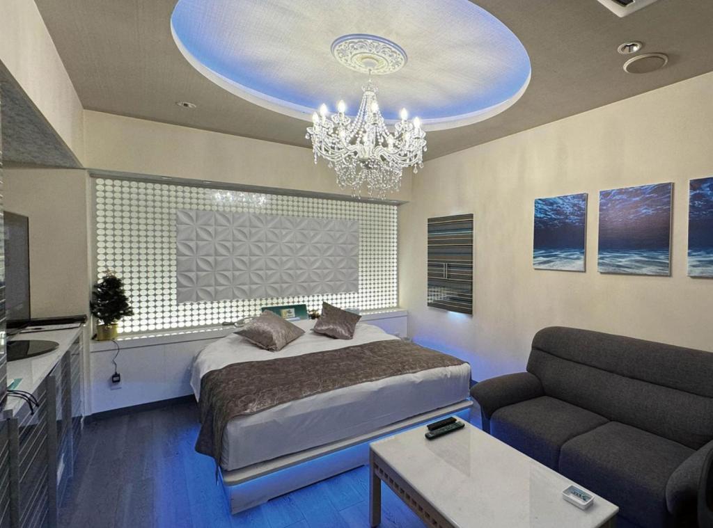 een slaapkamer met een groot bed en een kroonluchter bij ホテルメイプル in Odate