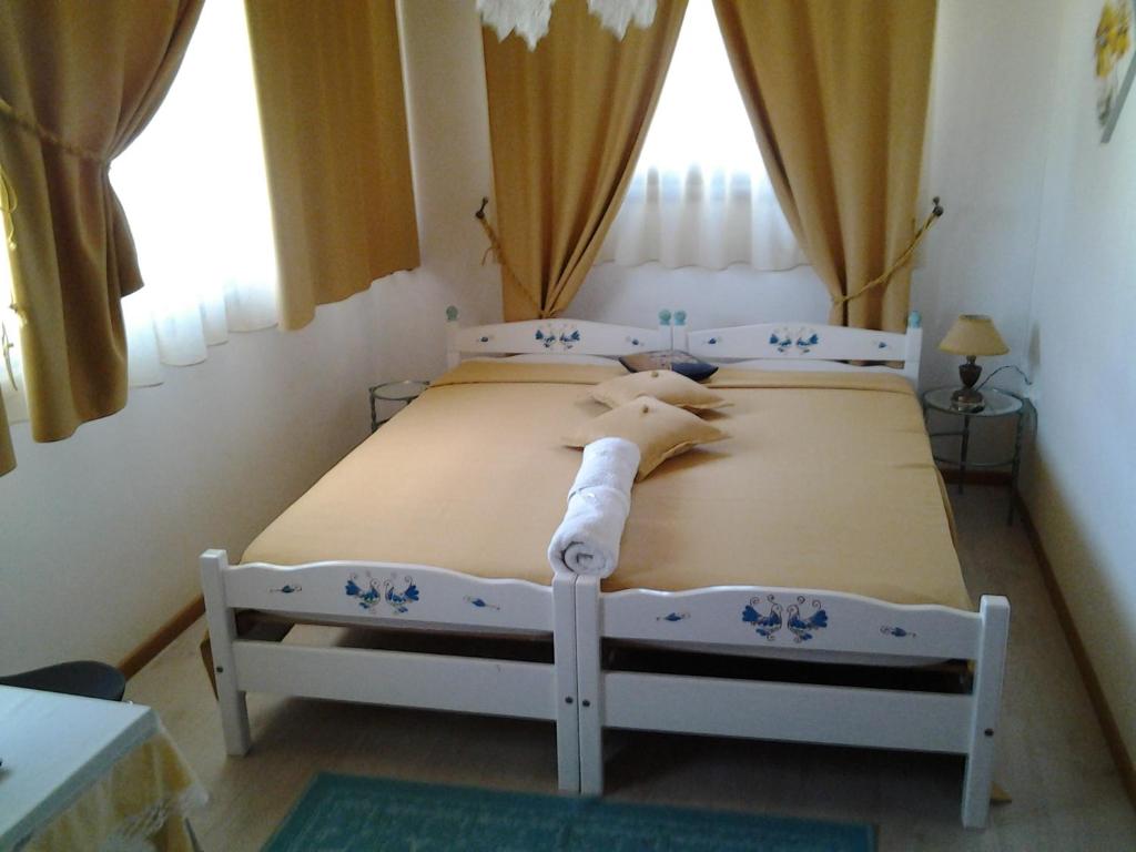 1 dormitorio con 2 camas y 2 ventanas en Sa Mariposa, en Ittiri