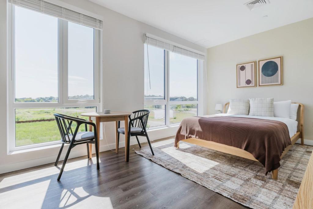 Un dormitorio con una cama y una mesa y sillas. en Blueground Revere courtyard games wd ac BOS-1092, en Boston