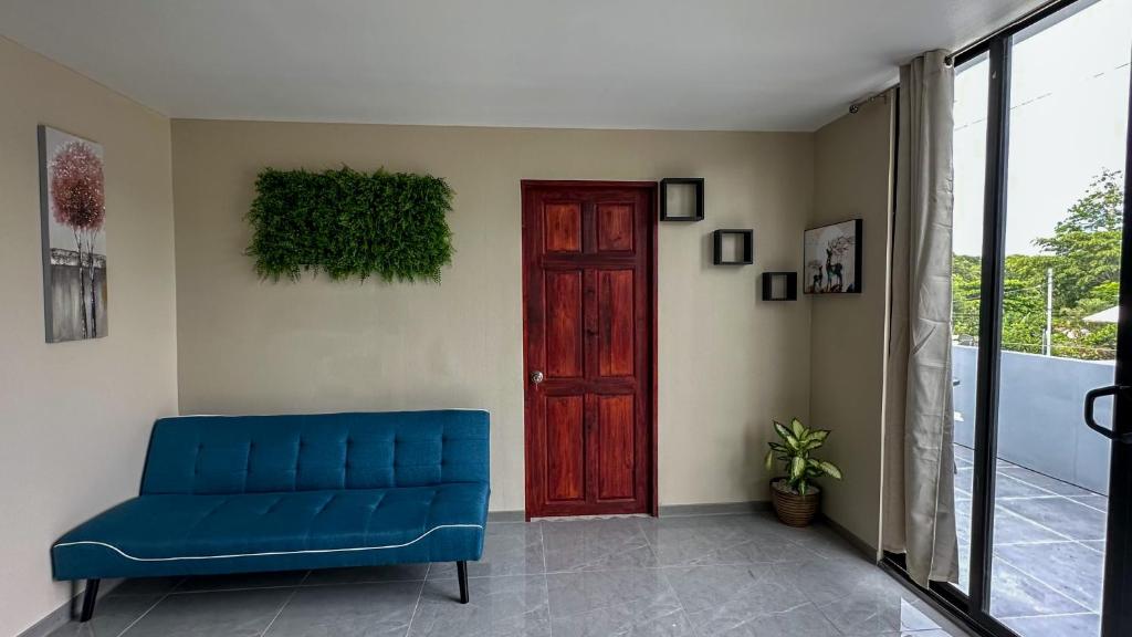 a blue couch in a room with a red door at Olas del alba in Tapantí