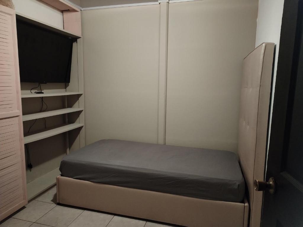 a small bedroom with a bed and a tv at Casa en San José de la Montaña in Heredia