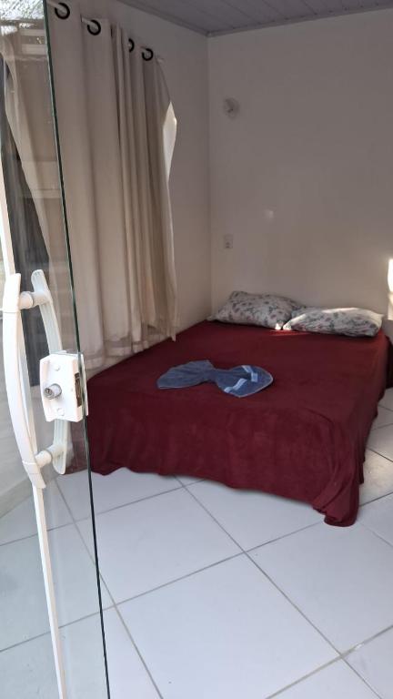 a bedroom with a bed with a red bedspread on it at Casa mar in Búzios