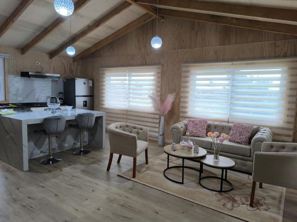 a kitchen and living room with a couch and a table at Hospedaje Punto Cero in Chaitén