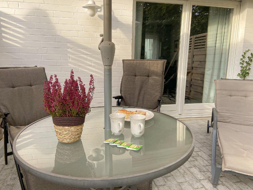 einen Glastisch mit Blumen auf einer Terrasse in der Unterkunft Heide Apartment Heimat in Schneverdingen