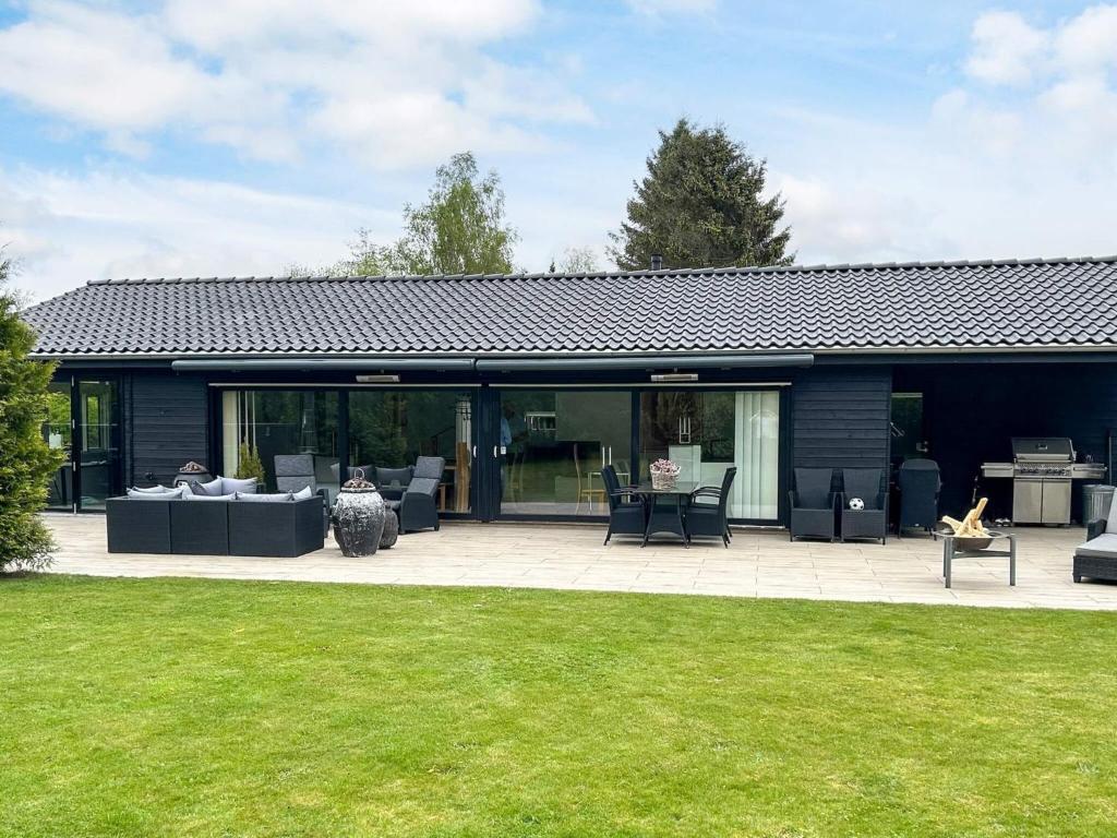 ein Haus mit Terrasse und Rasen in der Unterkunft 5 star holiday home in Silkeborg in Abildskov