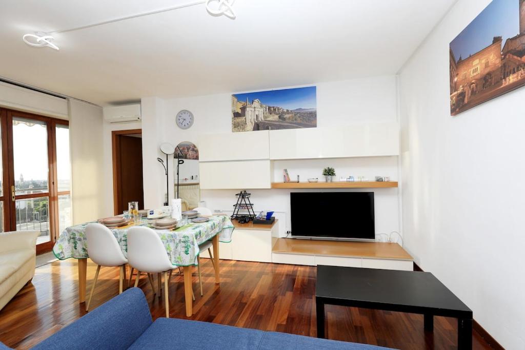 a living room with a table and a television at Luxury Panoramic Apt w Garage Happy Home Bergamo 2 in Bergamo