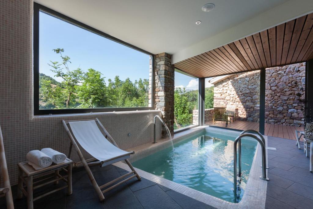 una piscina con una silla y una hamaca en una casa en Bonansa Country Hotel, en Bonansa
