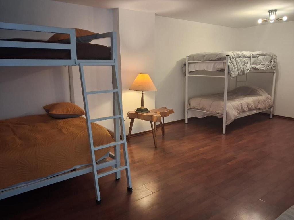 - une chambre avec 2 lits superposés et une table avec une lampe dans l'établissement Hostal Auditorio, à Mexico