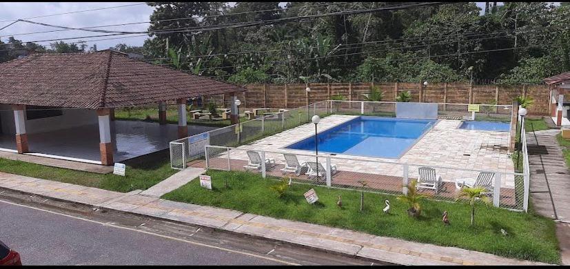 a swimming pool in a yard with chairs and an umbrella at Apartment in Ananindeua in Ananindeua
