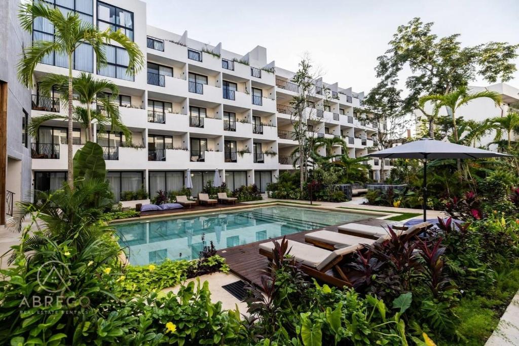 an apartment building with a swimming pool and a hotel at Xibalba Tulum in Tulum