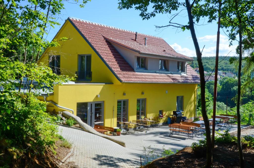 ブルノにあるMezi Stromyの赤屋根の黄色い家