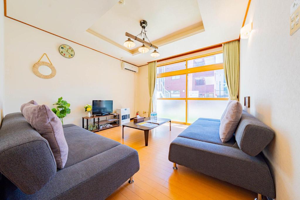 a living room with two couches and a tv at Extreme in Sapporo