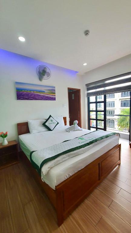 a bedroom with a large bed with a large window at Thành Hưng Motel in Hà Tiên