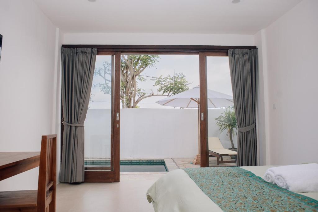a bedroom with a bed and a sliding glass door at Torok Papa villa in Selong Belanak