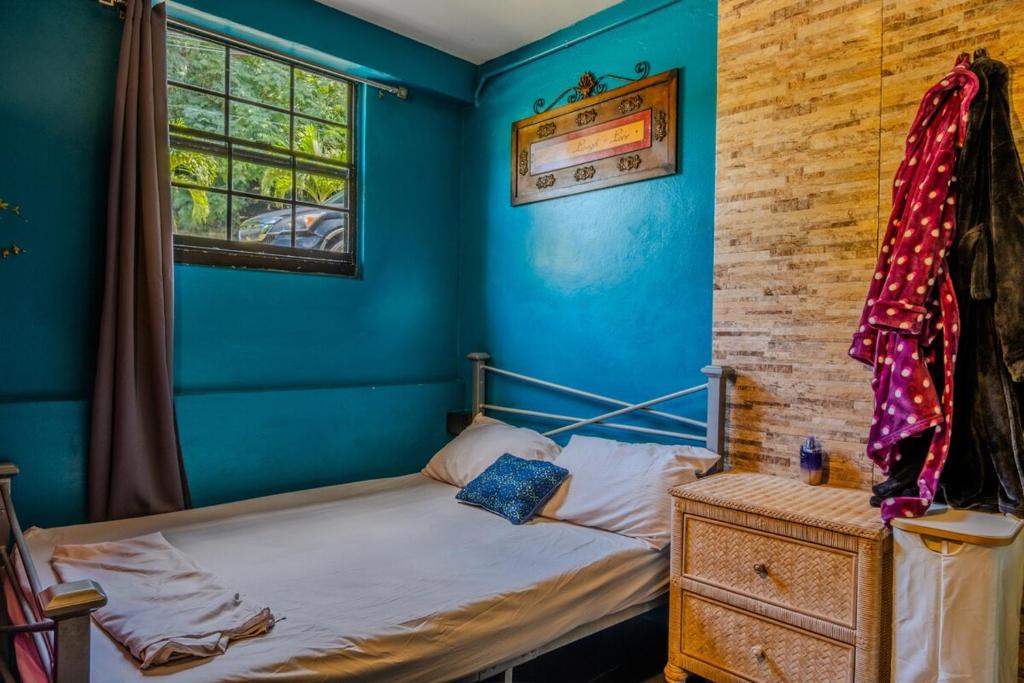 a blue bedroom with a bed and a window at Comfortable modern studio villa in Castries