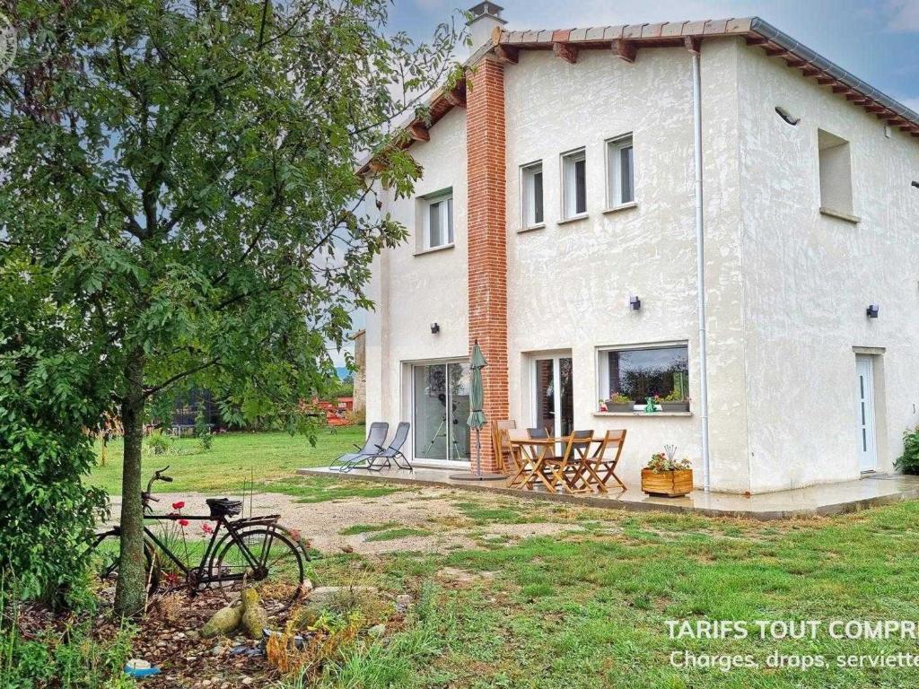 a large white house with a table and chairs at Gîte de charme pour 5 pers. avec terrasse privative dans la Loire - FR-1-496-375 in Grézieux-le-Fromental