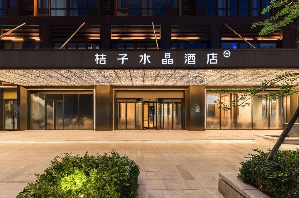 een ingang van een gebouw met een bord erop bij Orange Crystal Hotel Qingdao Taidong Pedestrian Street in Qingdao