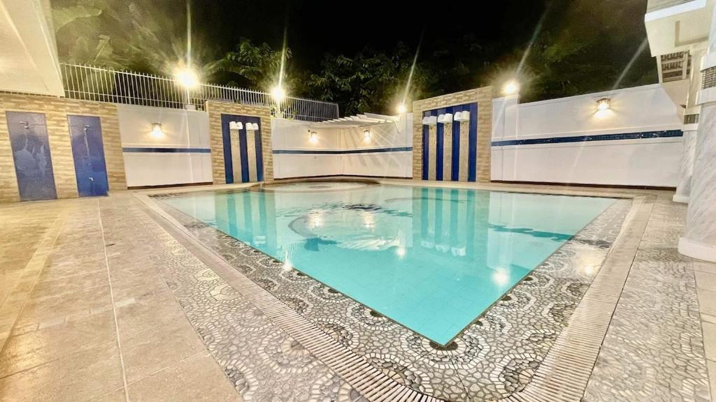 a large swimming pool in a building at night at La Roma - Hot Spring Private Resort in Pansol