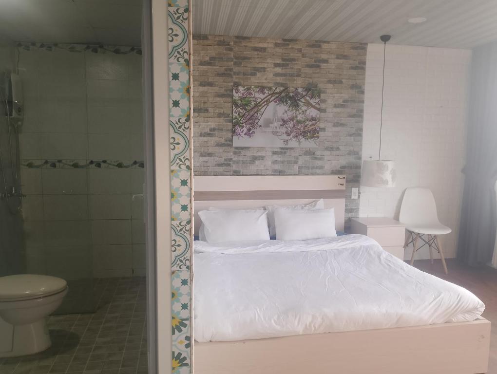 a bed with white sheets and pillows in a bedroom at Đối diện cafe CATINAT villa Kagen in Da Lat