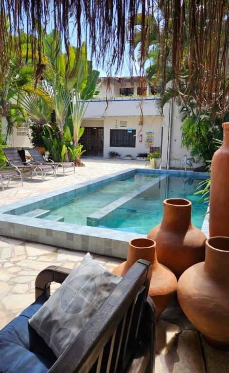 a swimming pool with a bench next to a building at Graciosa Suites in Praia do Frances
