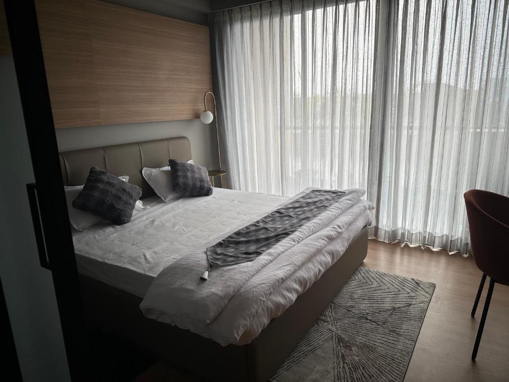 a bedroom with a bed and a large window at Bloom Studio Suites in Raipur