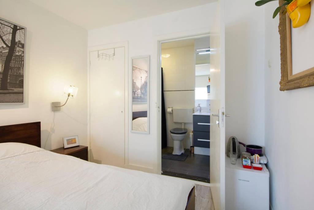 a bedroom with a bed and a bathroom with a toilet at H 58 in Amsterdam