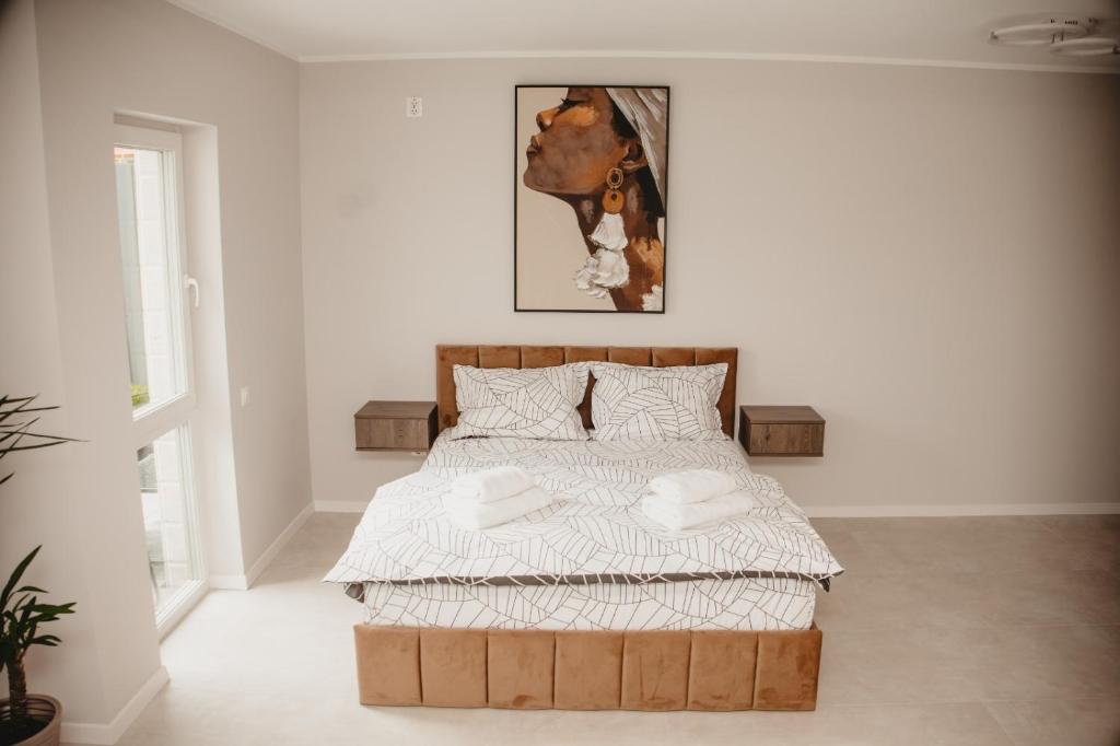 クルジュ・ナポカにあるWhite House Iris Cluj Napoca - Apartament 1の白い部屋に木製ベッド1台が備わるベッドルーム1室