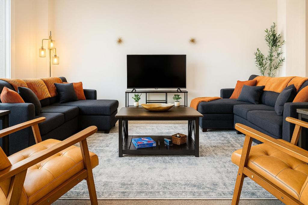 a living room with two couches and a tv at Spacious 2BR Loft - near CSU, Playhouse, Progressive field, R&R Hall of Fame - Gym & Sauna in Cleveland