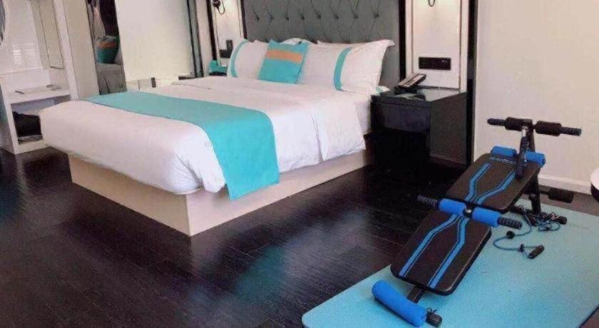 a bedroom with a bed with a camera on the floor at Xana Hotelle Neijiang City Center Branch in Neijiang