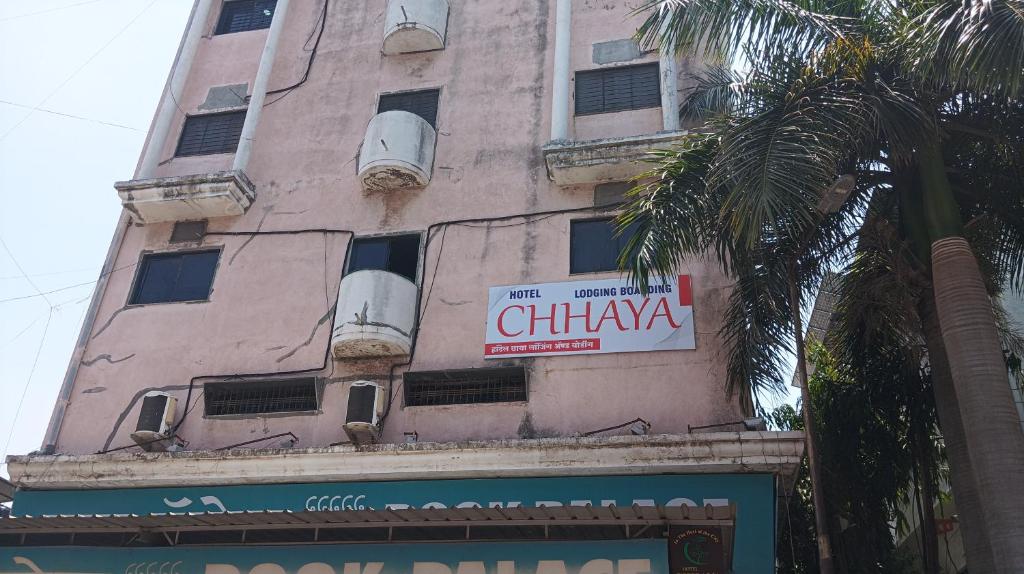 een hoog roze gebouw met een bord erop bij Hotel chhaya in Aurangabad