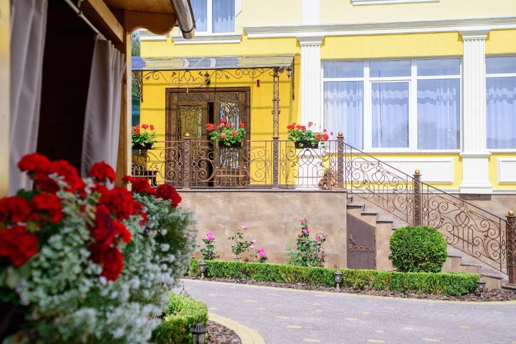 a yellow house with flowers on the front door at Argo Premium in Lviv