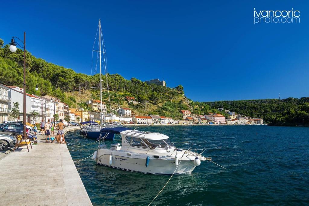 a boat is docked at a dock in the water at Apartment Niksa in Novigrad Dalmatia
