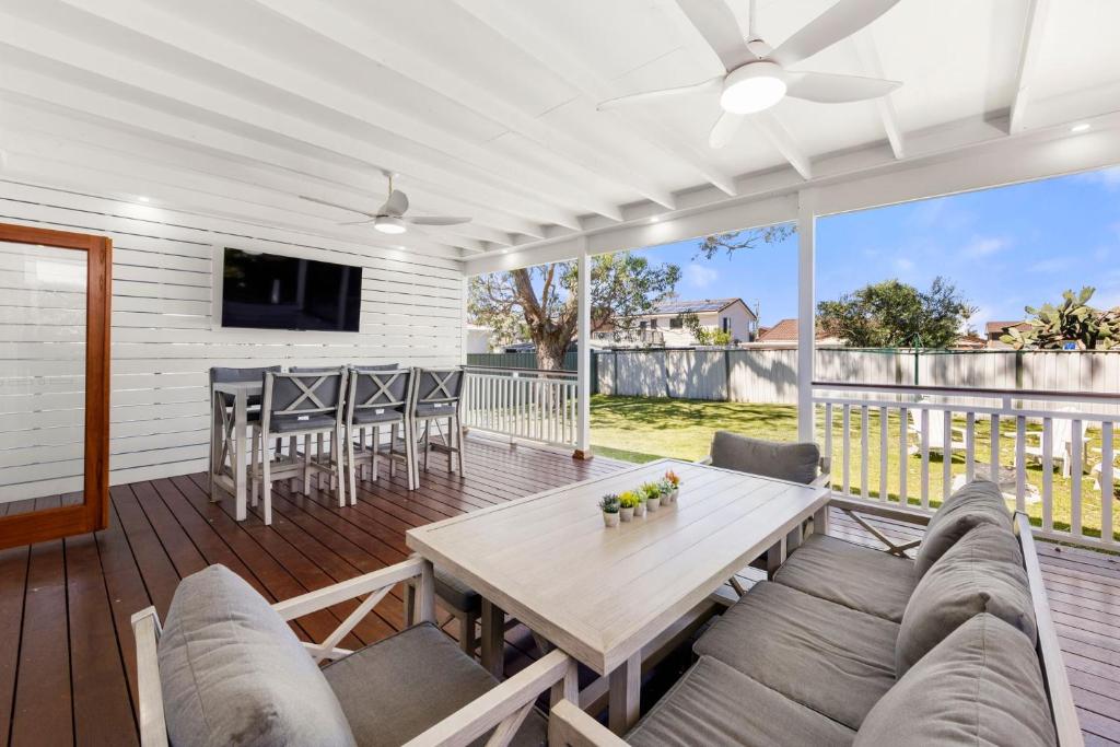 a screened in porch with a table and chairs at Barronstown - Pet Friendly with Fire Pit in Callala Beach