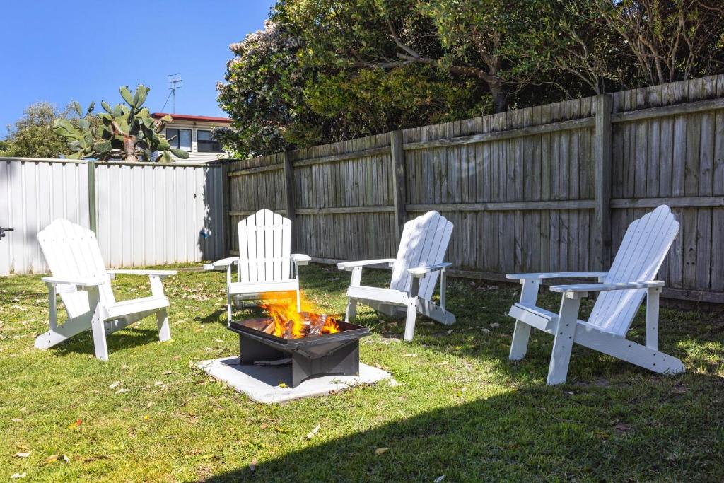 three chairs and a fire pit in a yard at Barronstown - Pet Friendly with Fire Pit in Callala Beach