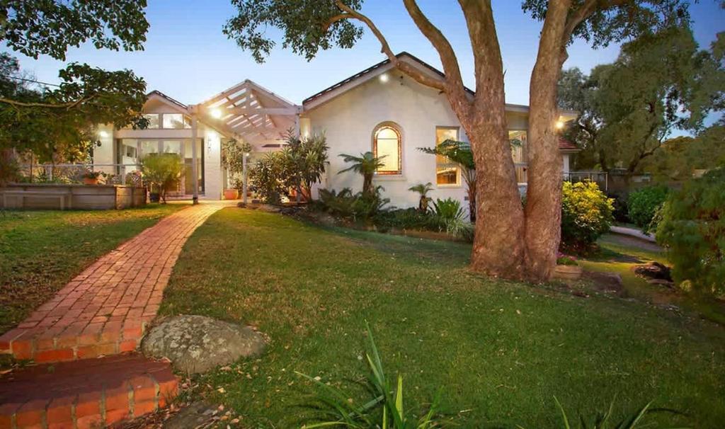 una casa bianca con un albero e un vialetto di mattoni di Serene & Classic Family Retreat by the Yarra a Warrandyte