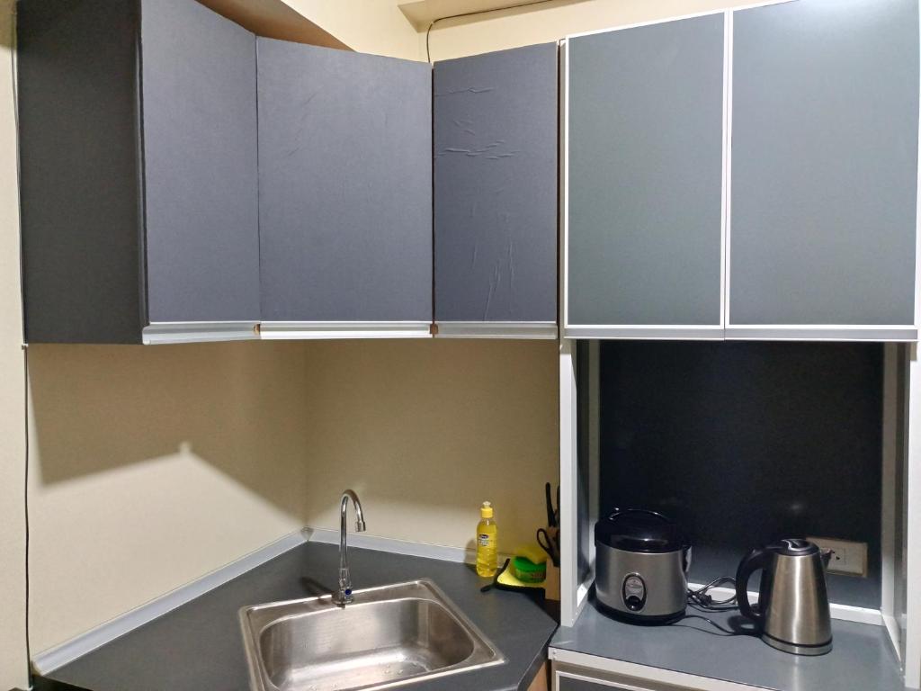 a kitchen with gray cabinets and a sink at Stena Stays in Kaybagal