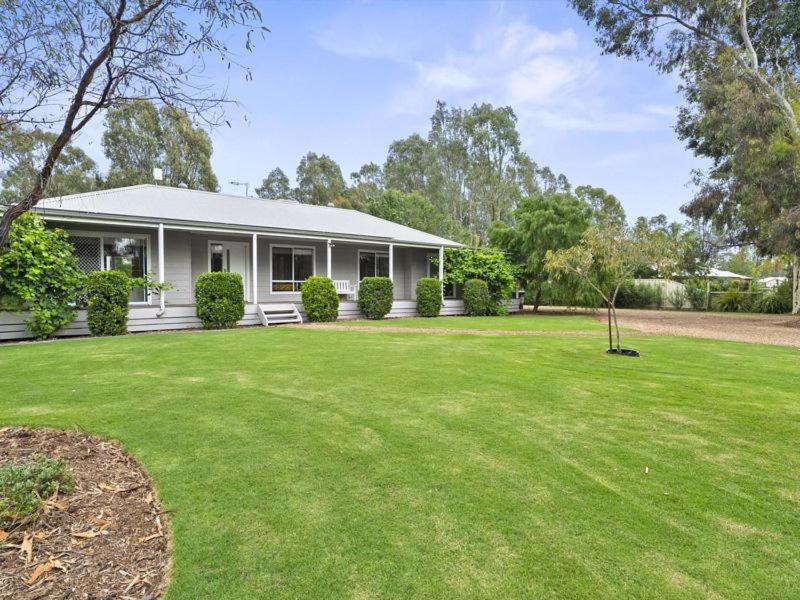 a white house with a green lawn in front of it at River Retreat in Yarrawonga