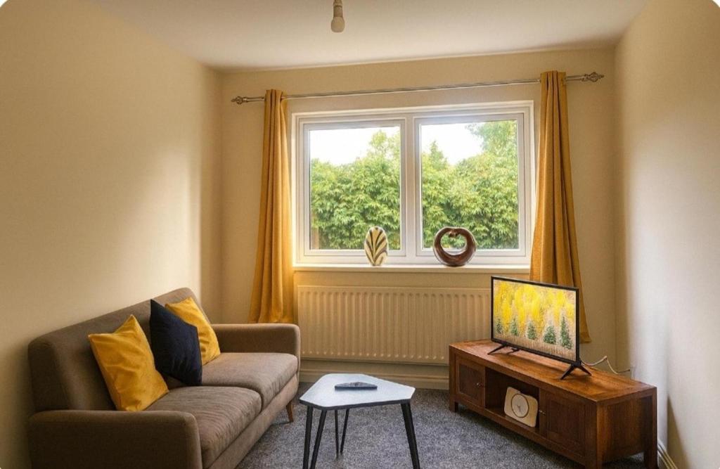 a living room with a couch and a window at Rochdale Retreat - Cozy Apartment Stay in Milnrow