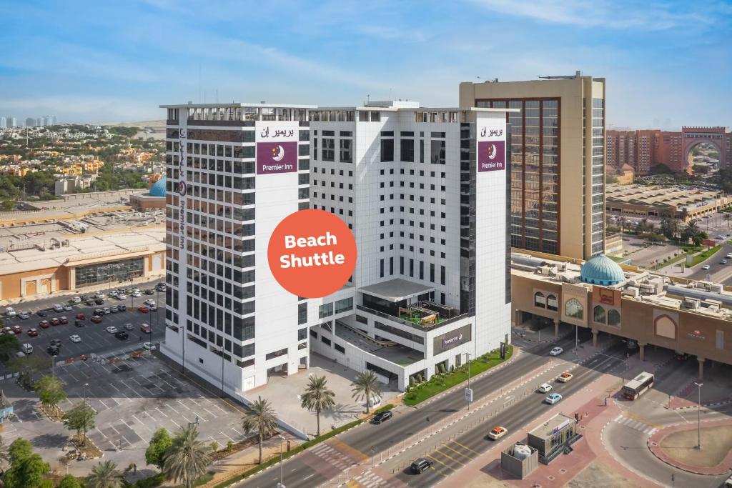 a large white building with a red sign on it at Premier Inn Dubai Ibn Battuta Mall in Dubai