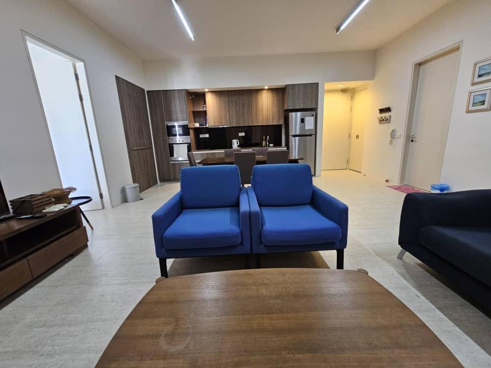 a living room with blue chairs and a couch at By The Sea with Side Seaview #363A in Batu Ferringhi