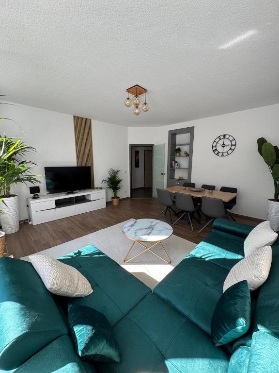 a living room with a green couch and a table at Apartment Stadtperle in Gotha