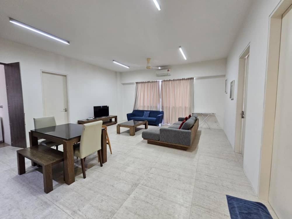 uma sala de estar com um sofá e uma mesa em By The Sea Partial Seaview n Mountain View 383 em Batu Ferringhi