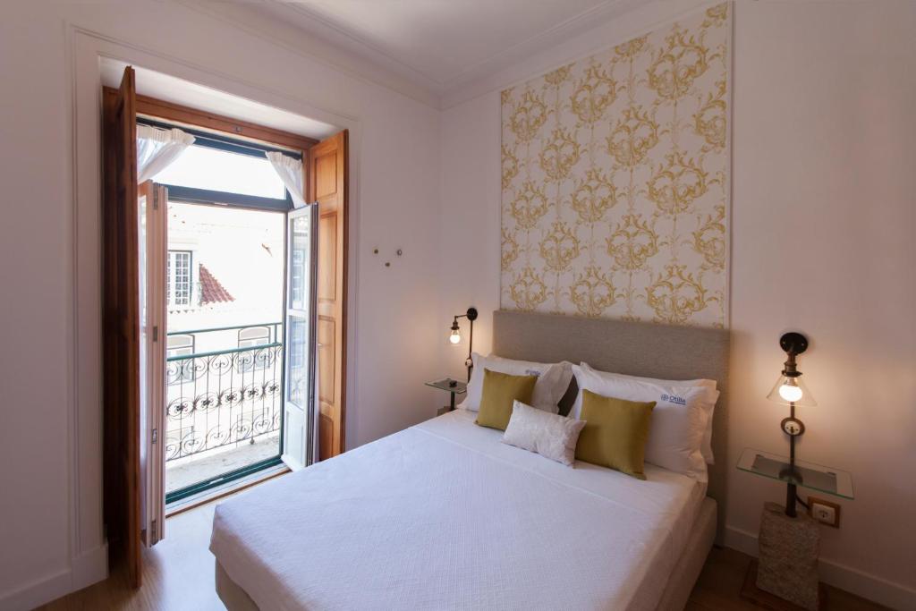 a bedroom with a white bed and a window at Otília Apartamentos in Lisbon