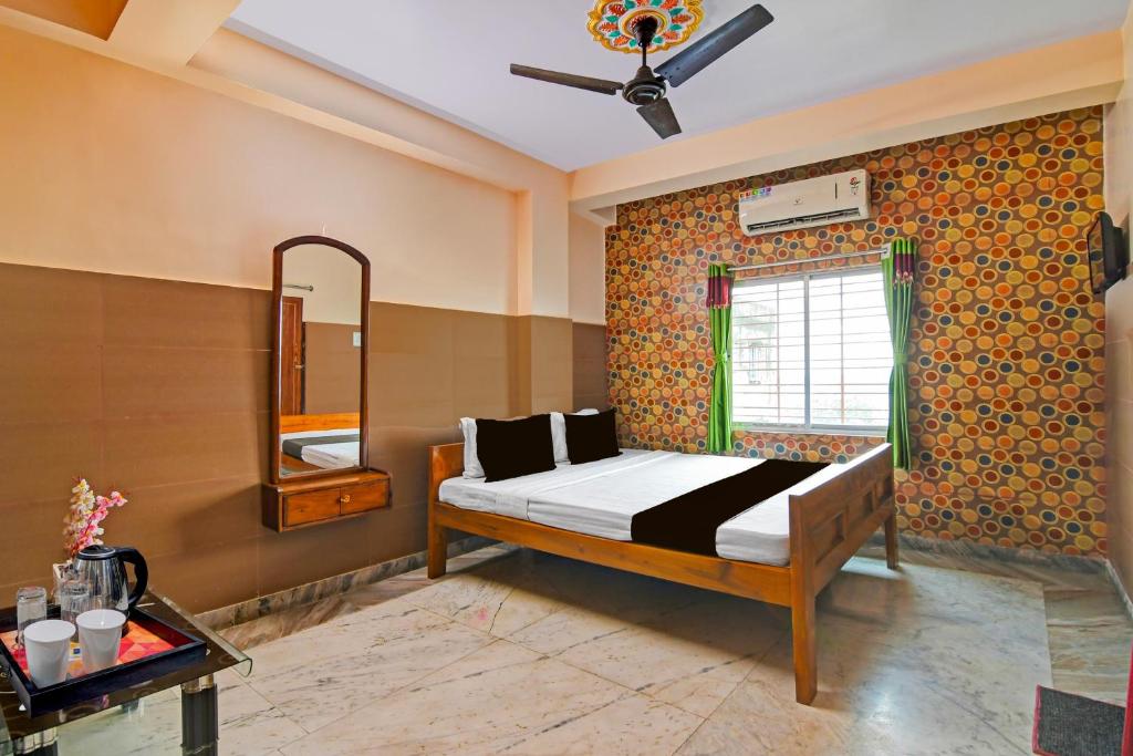un dormitorio con una cama y un espejo en Super Hotel O Rishra Railway Station Formerly Green Guest House, en Khardah