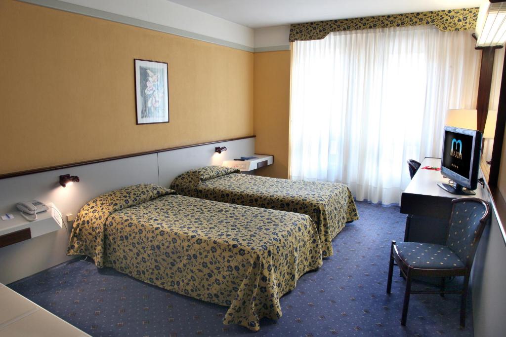 Postel nebo postele na pokoji v ubytování Hotel Maxim
