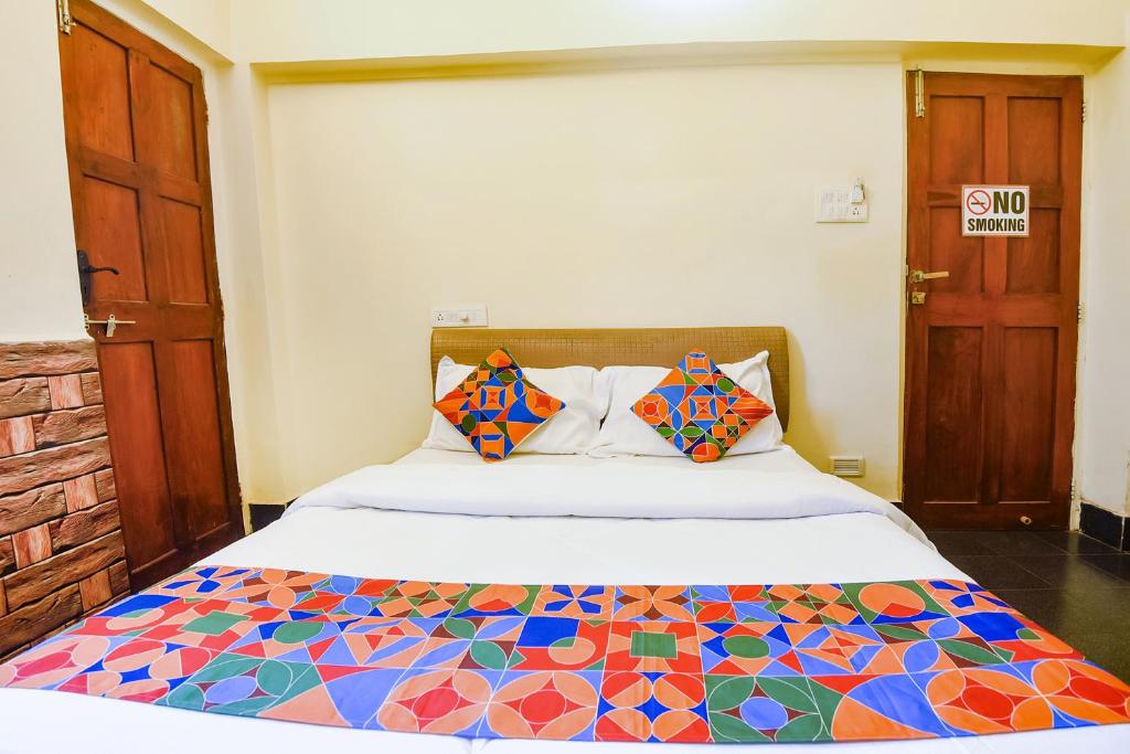 a bedroom with a bed with a colorful quilt at FabExpress Royal Baga Residency - 500m From Baga Beach in Old Goa