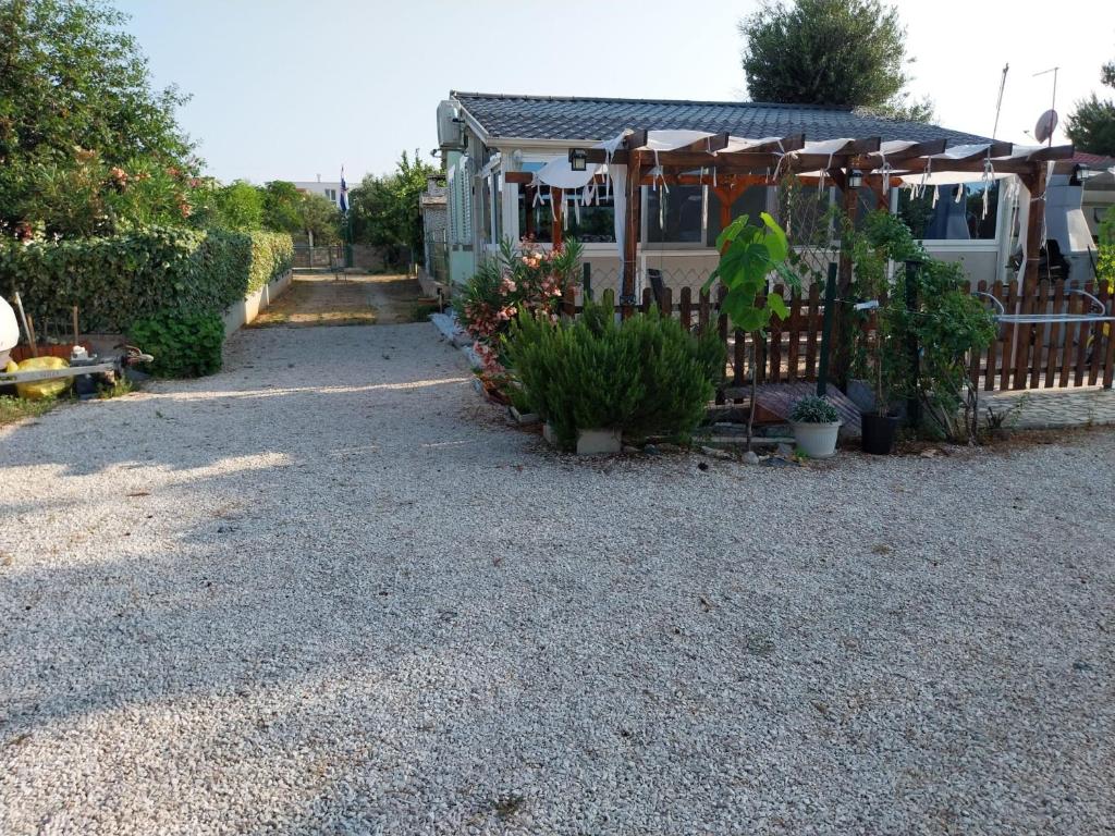 ein Wohnmobil mit einem Zaun und einigen Pflanzen in der Unterkunft Apartment Oaza in Rogoznica