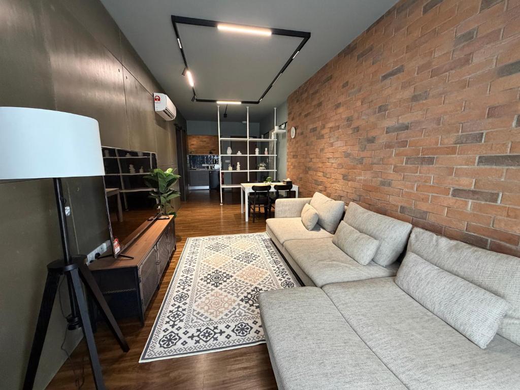 Kampong TangihanにあるTF Luxe Suites K Avenue Kepayanのレンガの壁のリビングルーム(ソファ付)