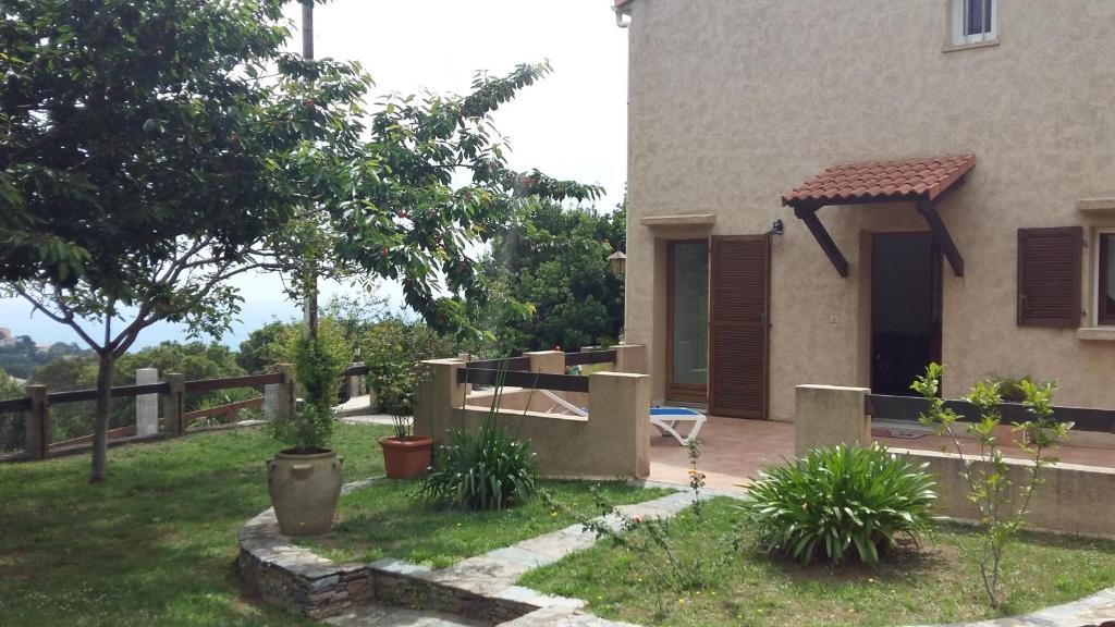 een huis met een tuin met een hek bij Bas de Villa chez Mr.Girolami Dominique in Bastia