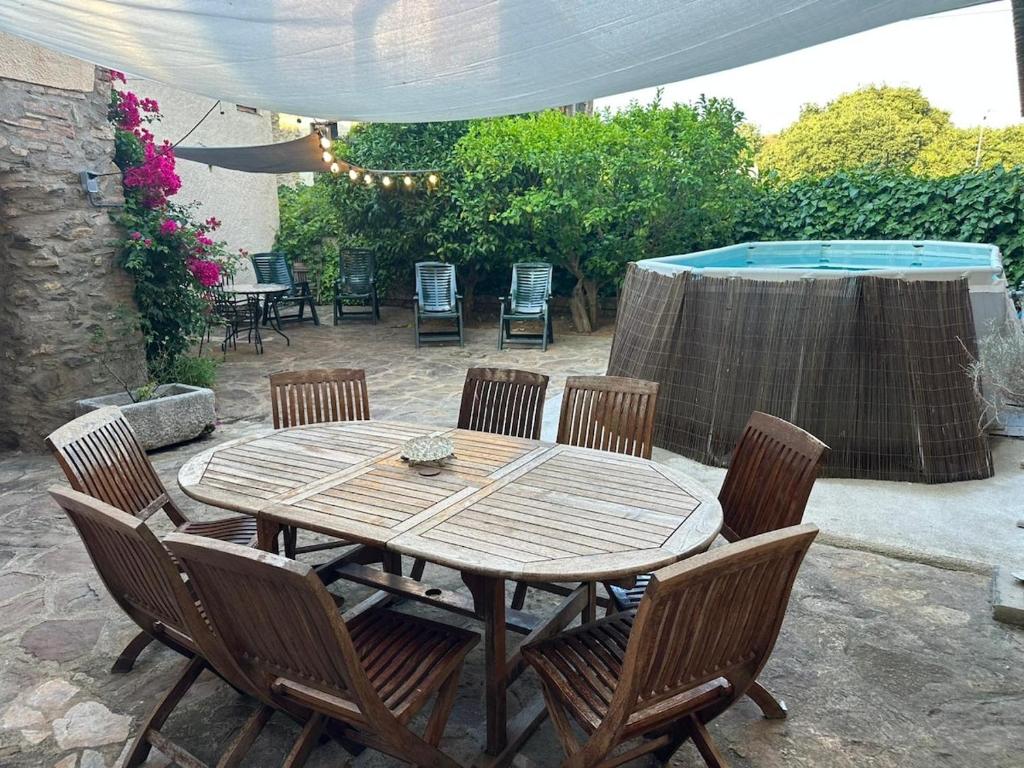 a wooden table and chairs on a patio at Charming village house for families & cyclists in Juià